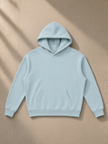Oversize fleeced hoodie in Light Blue, laid flat on pale limestone