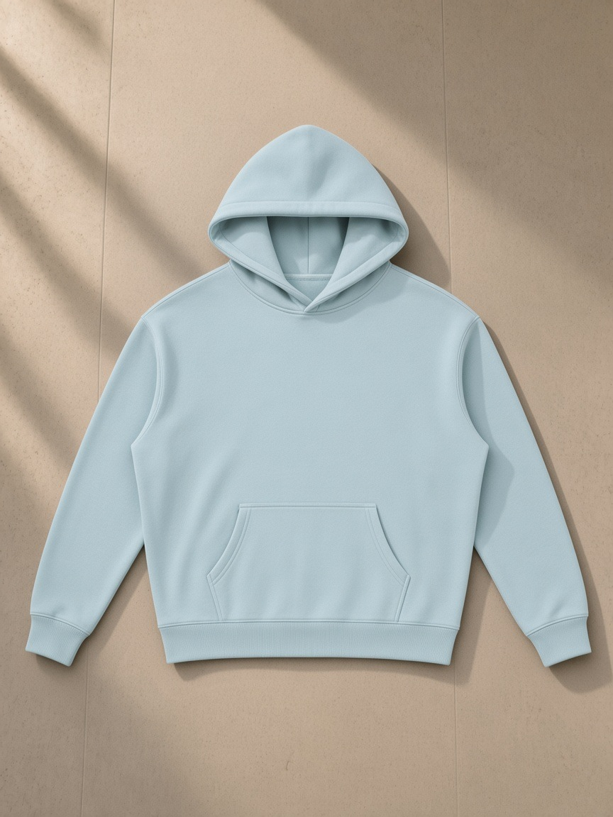 Oversize fleeced hoodie in Light Blue, laid flat on pale limestone