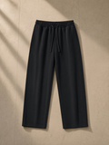 Straight Leg Sweatpants in Black, laid flat on pale limestone