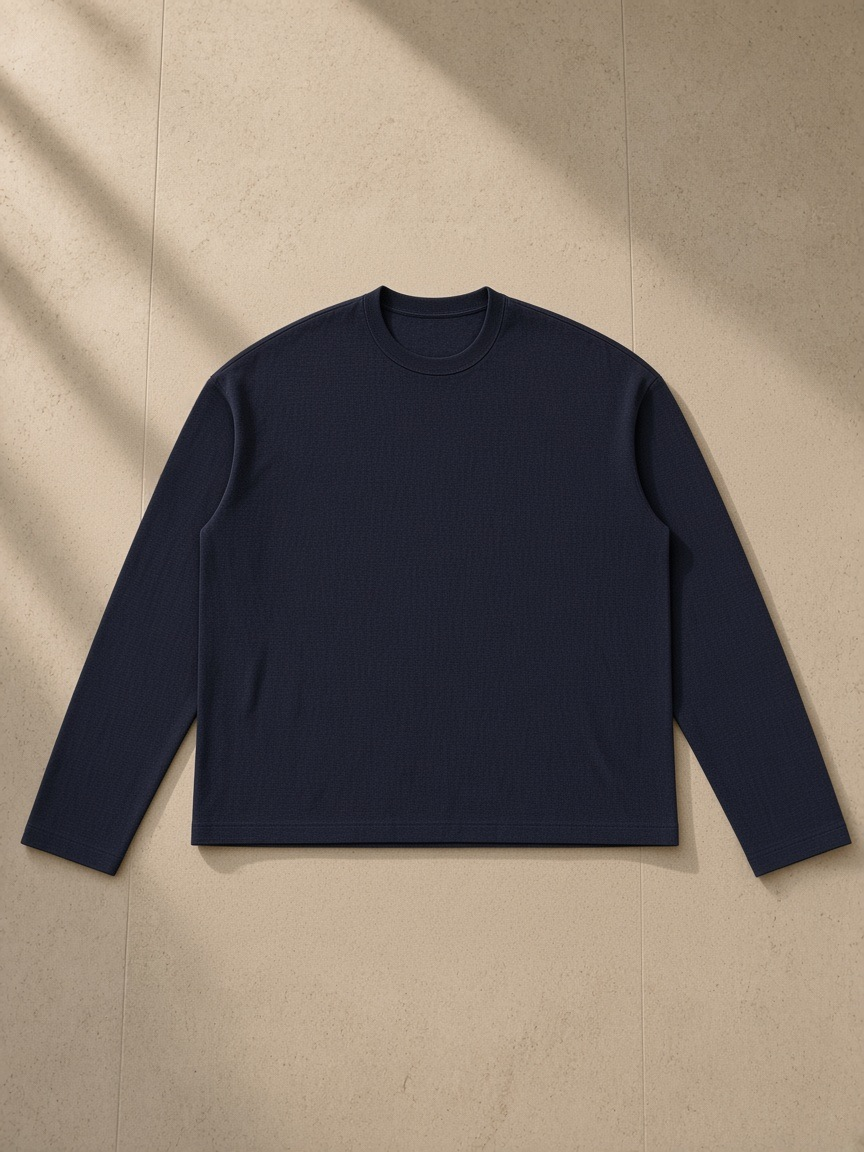 Raw Edge Long Sleeve T-Shirt in Navy Blue, laid flat on pale limestone