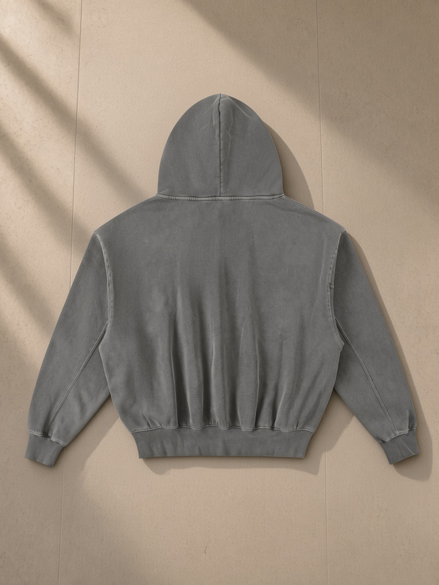 Frayed Enzyme Washed Fleece Hoodie in Dark Gray, laid flat on pale limestone, back view