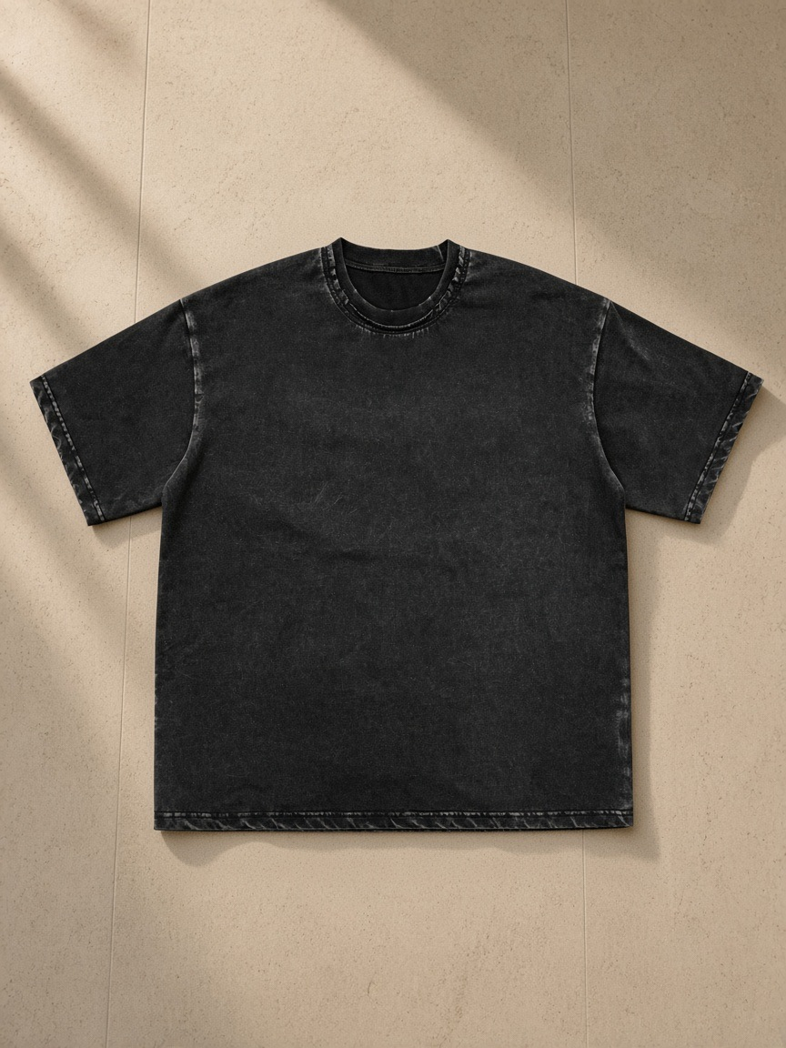 Snow washed raw-edge neckline t-shirt in Black, laid flat on pale limestone