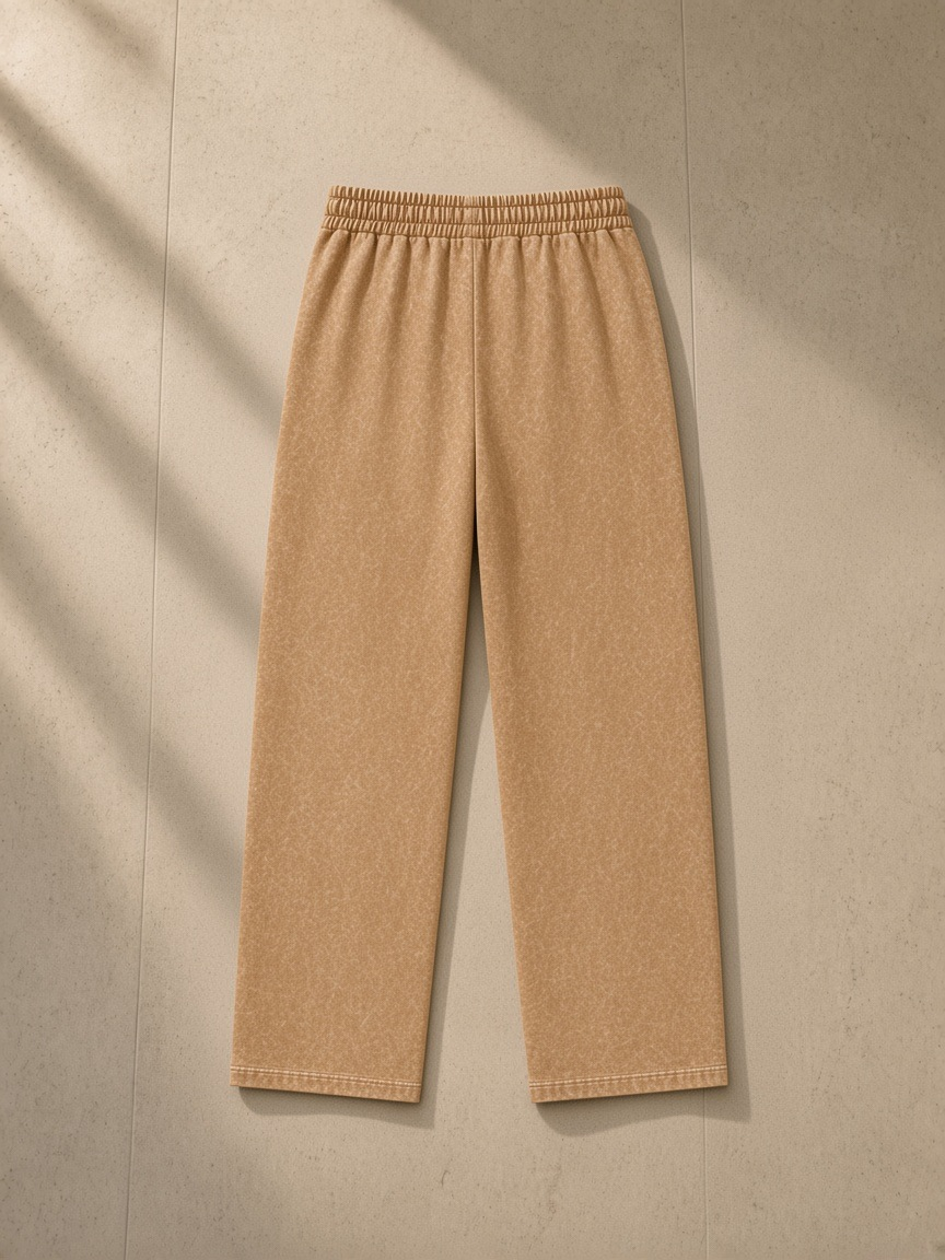 Unisex snow wash heavyweight sweatpants in Brown, laid flat on pale limestone, back view