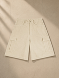 Woven cargo shorts in Apricot, laid flat on pale limestone