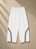 Wide Leg Piping Sweatpants in White, laid flat on pale limestone