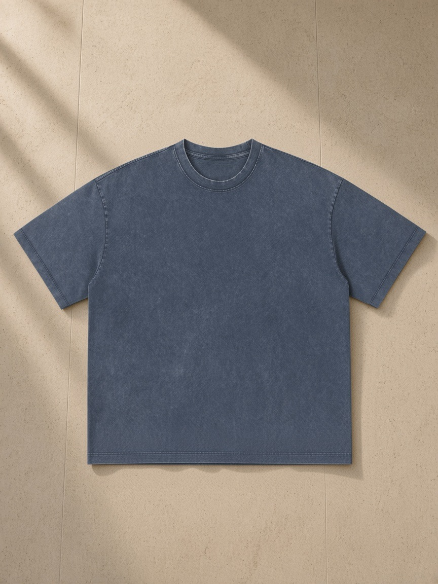 Unisex vintage wash boxy t-shirt in Navy Blue, laid flat on pale limestone