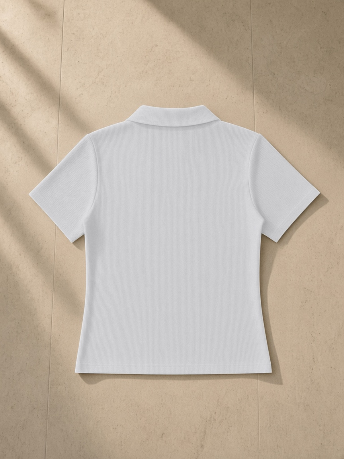 Bodycon Short Sleeve Polo Shirt in Gray, laid flat on pale limestone, back.