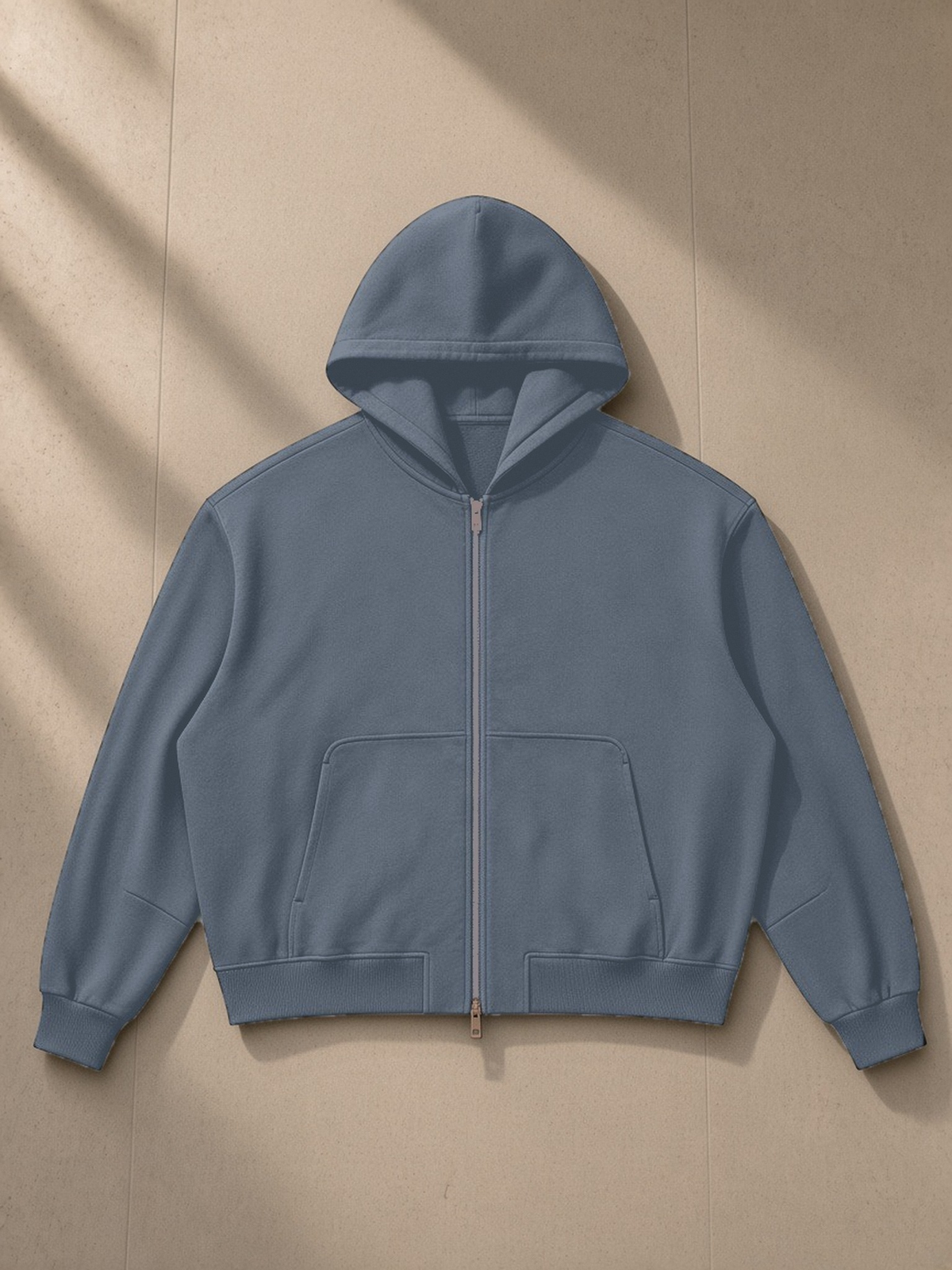 Vintage Wash Boxy Full Zip Hoodie in Gray Blue, laid flat on pale limestone, front view