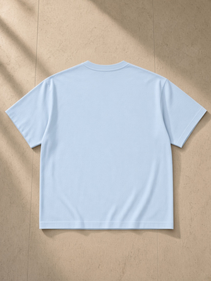 Essential Cotton Boxy T-Shirt in Sky Blue, laid flat on pale limestone, back.
