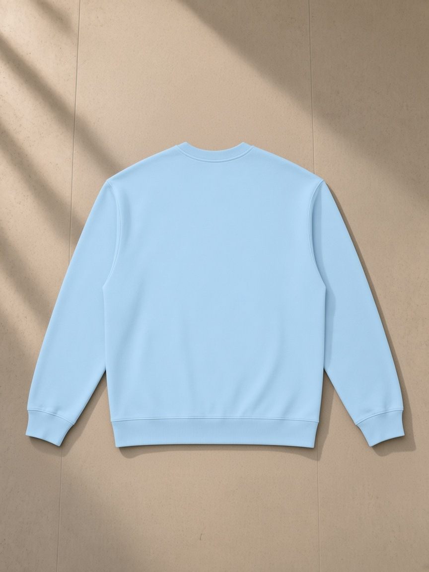 Oversized Crewneck Sweatshirt in Light Blue, laid flat on pale limestone, back view