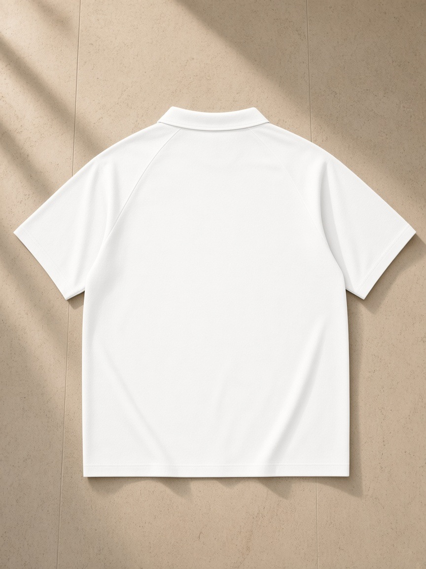 Classic Knit Polo in White, laid flat on pale limestone, back view
