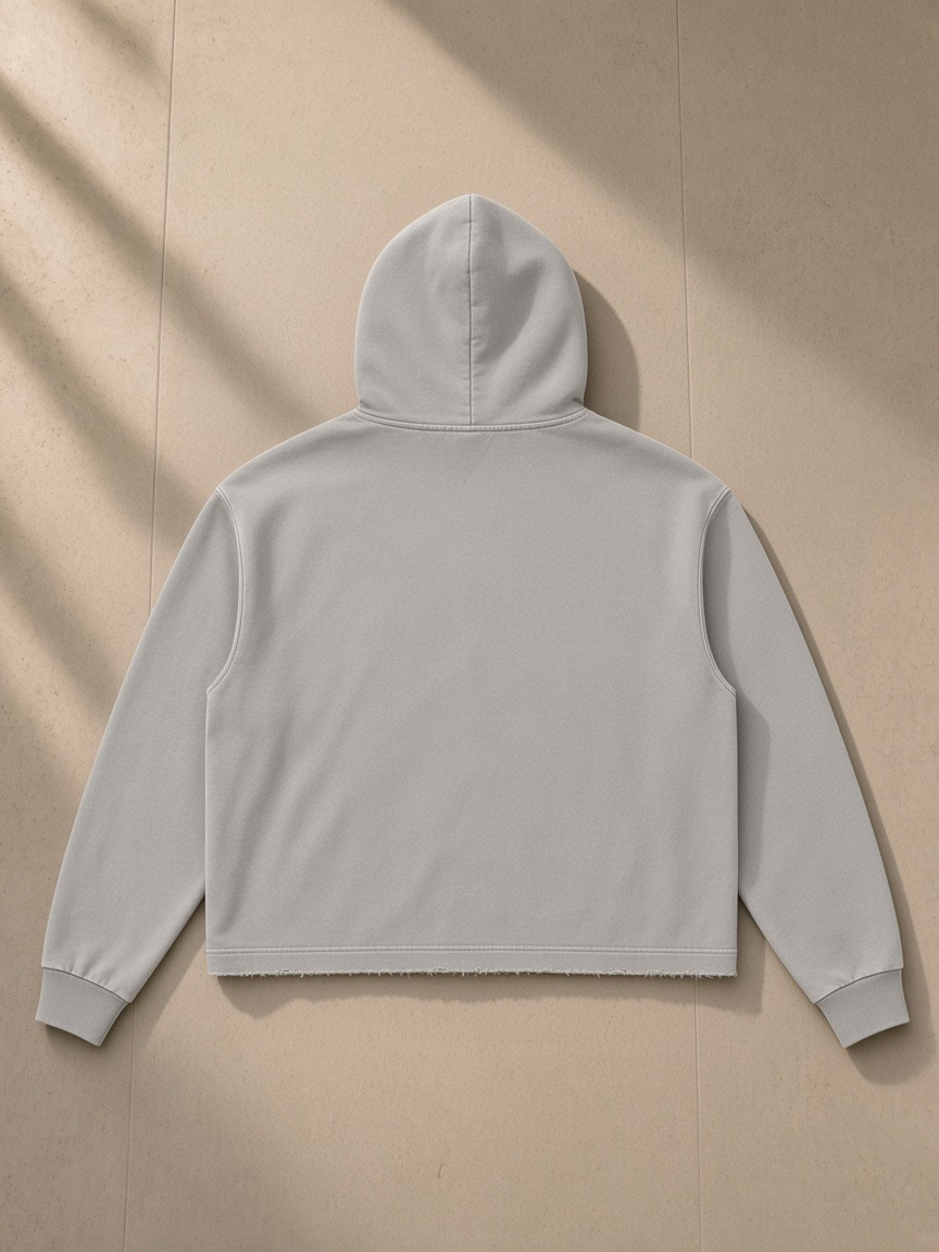 Vintage washed frayed-hem hoodie in Gray Apricot, laid flat on pale limestone, back view