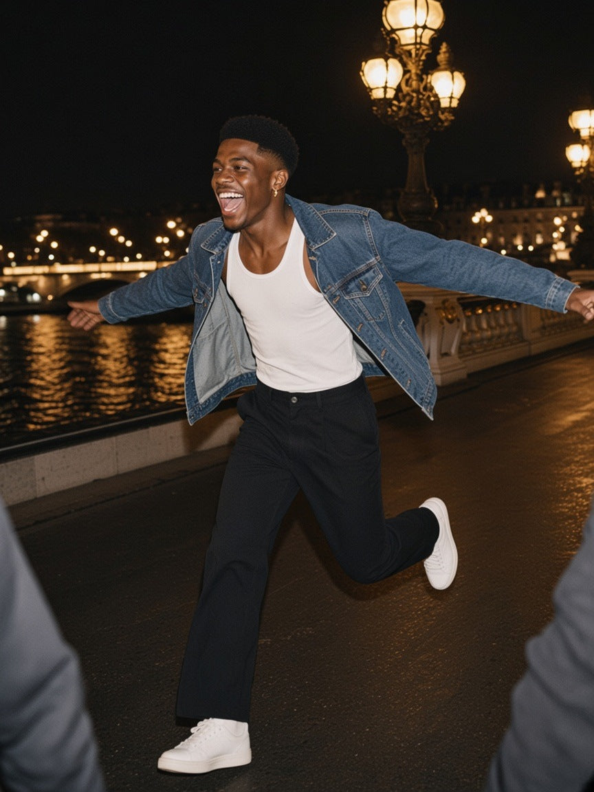 Man in the Marcel Afters Adjustable Waist Straight-Leg Pants in Black with a denim jacket, running arms-out across the Pont Alexandre III in Paris at 2am