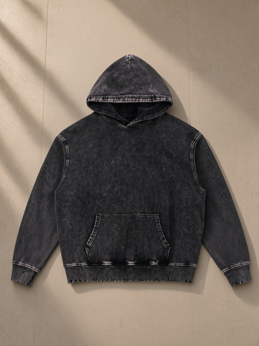 Snow Wash Hand-Frayed Heavyweight Hoodie in Black, laid flat on pale limestone