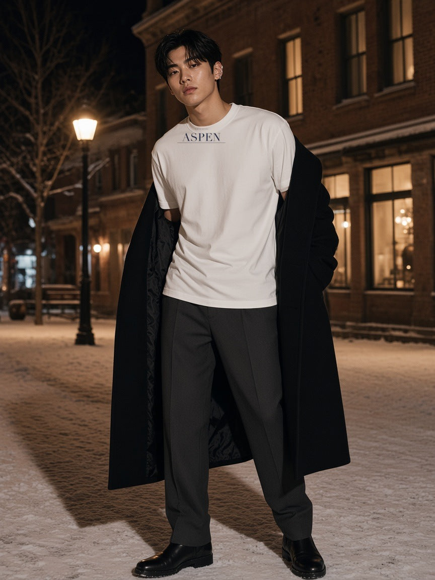 Man in the Aspen Heavyweight Drop Shoulder T-Shirt in White on a snowy street in Aspen at night