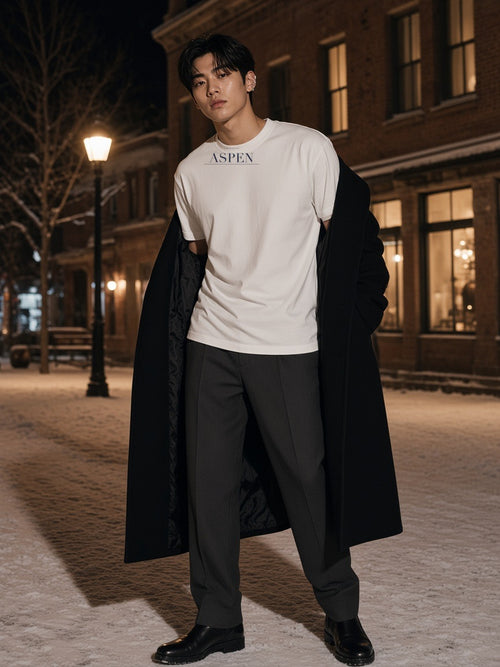 Man in the Aspen Heavyweight Drop Shoulder T-Shirt in White on a snowy street in Aspen at night