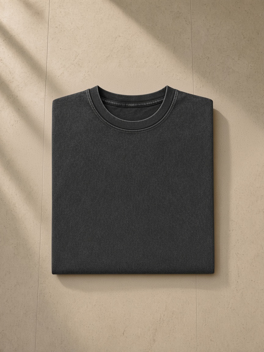 Women's Snow Washed Heavyweight Oversize T-Shirt in Black, folded on pale limestone, detail.