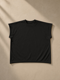 Unisex raw edge boxy non-shrink t-shirt in Black, laid flat on pale limestone