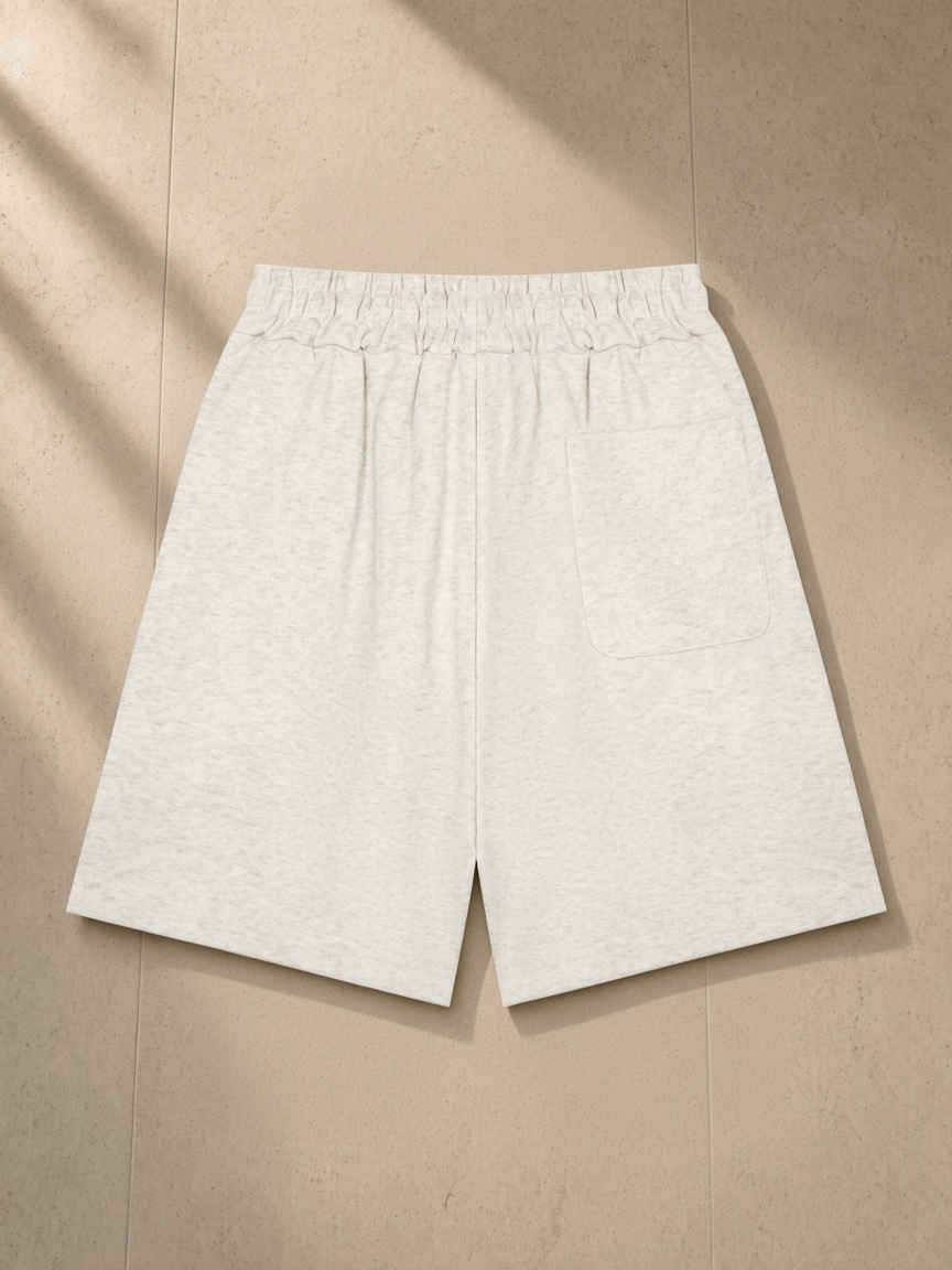Heavyweight Shorts in Oat Gray, laid flat on pale limestone, back.