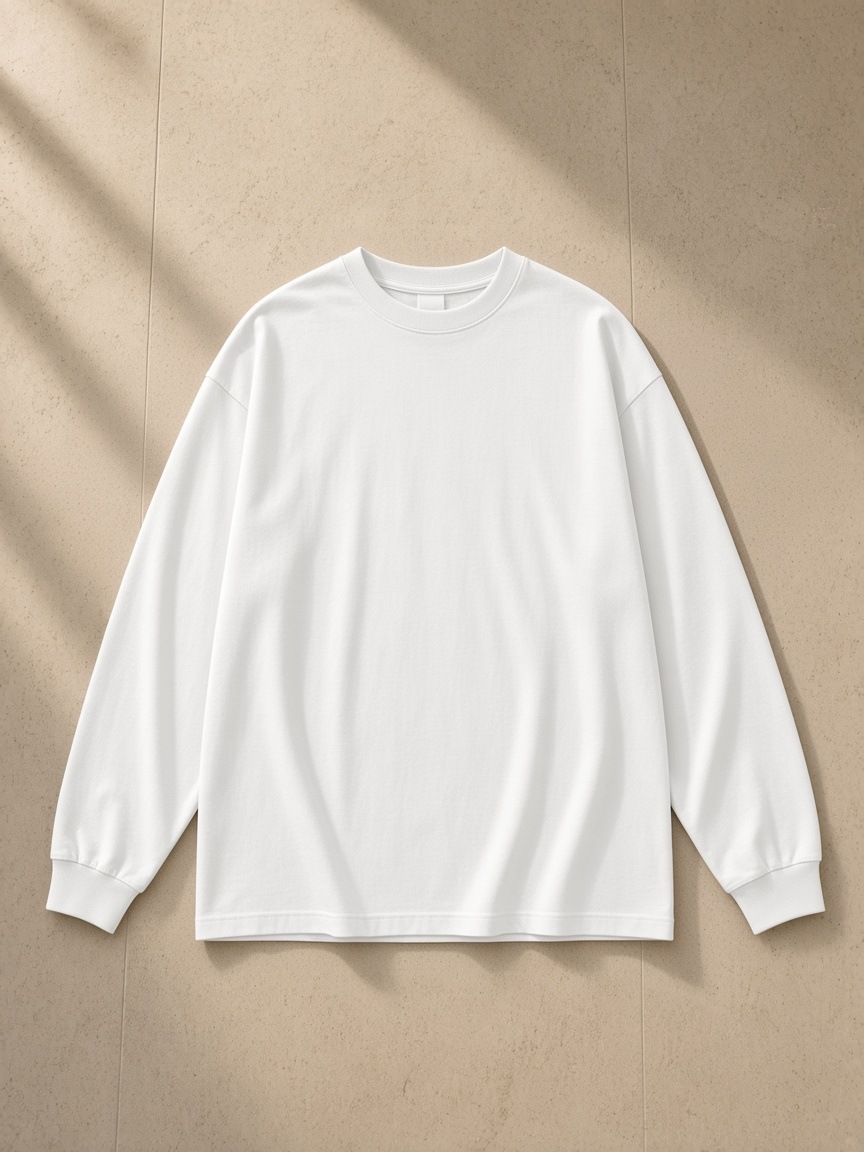 Oversized Long Sleeve T-Shirt in White, laid flat on pale limestone
