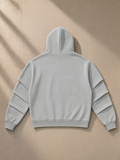 Unisex heavyweight ruched sleeves hoodie in Flower Gray, laid flat on pale limestone, back view
