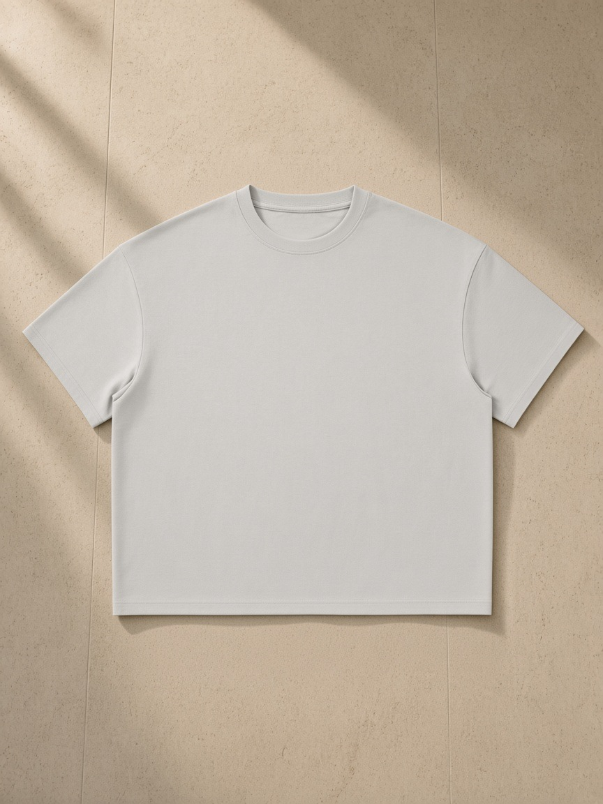 Unisex boxy Coolmax t-shirt in Gray, laid flat on pale limestone