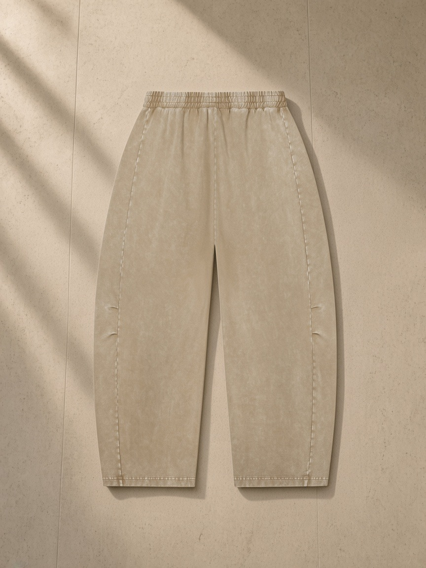 Unisex mineral wash barrel leg pants in Khaki, laid flat on pale limestone, back view