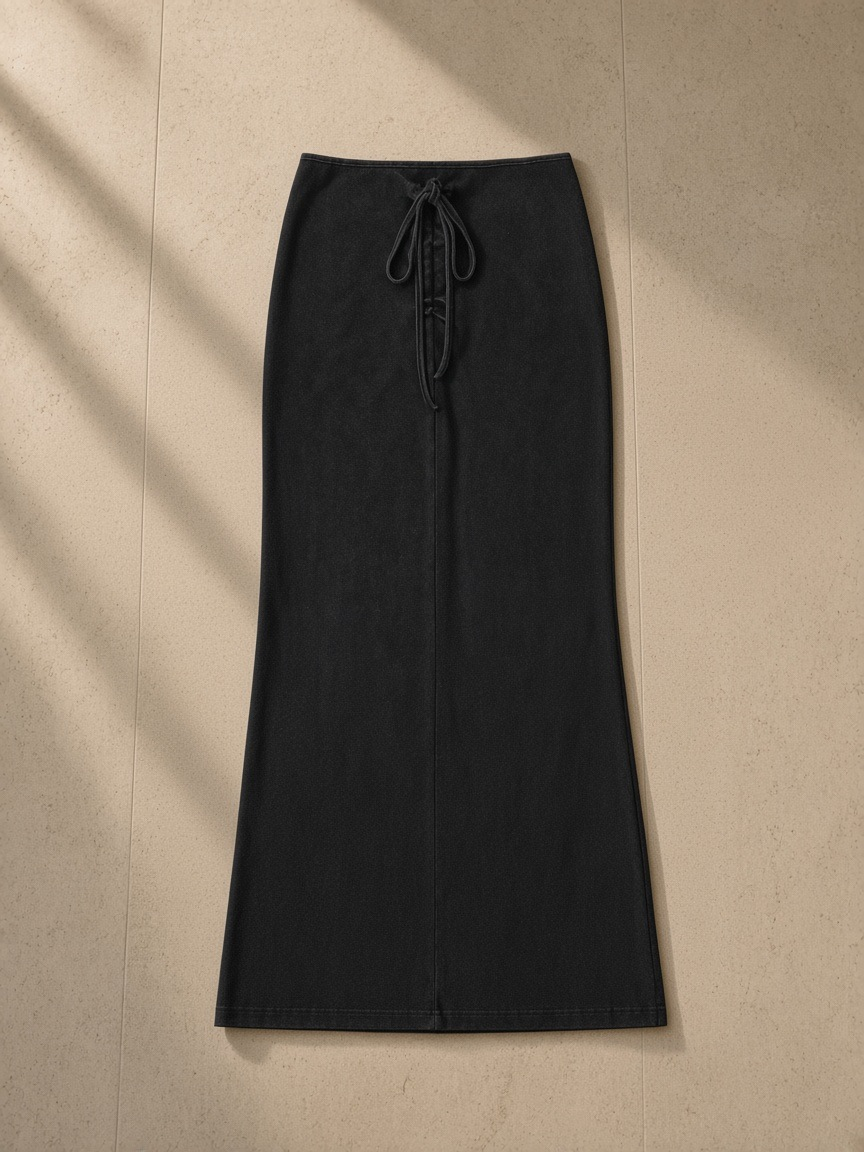 Dyed washed drawstring maxi skirt in Washed Black, laid flat on pale limestone