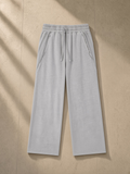 Snow Washed Tape Raw Edge Sweatpants in Light Gray, laid flat on pale limestone, front.
