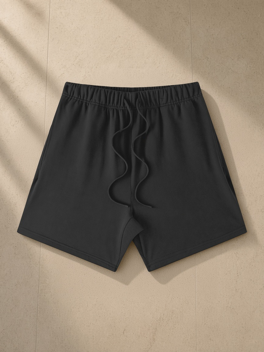 Earth Tone Loose Fit Cotton Shorts in Carbon Gray, laid flat on pale limestone