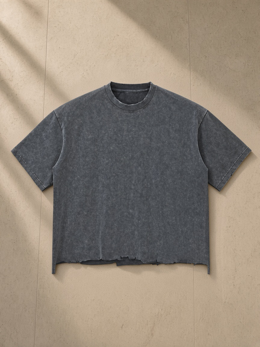 Unisex snow wash raw-hem boxy t-shirt in Washed Cement Gray, laid flat on pale limestone
