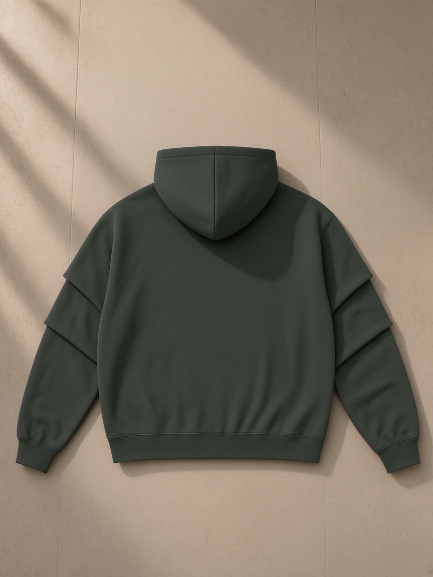 Unisex heavyweight ruched sleeves hoodie in Dark Gray, laid flat on pale limestone, back view