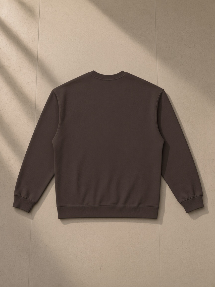 Oversized Crewneck Sweatshirt in Dark Brown, laid flat on pale limestone, back view