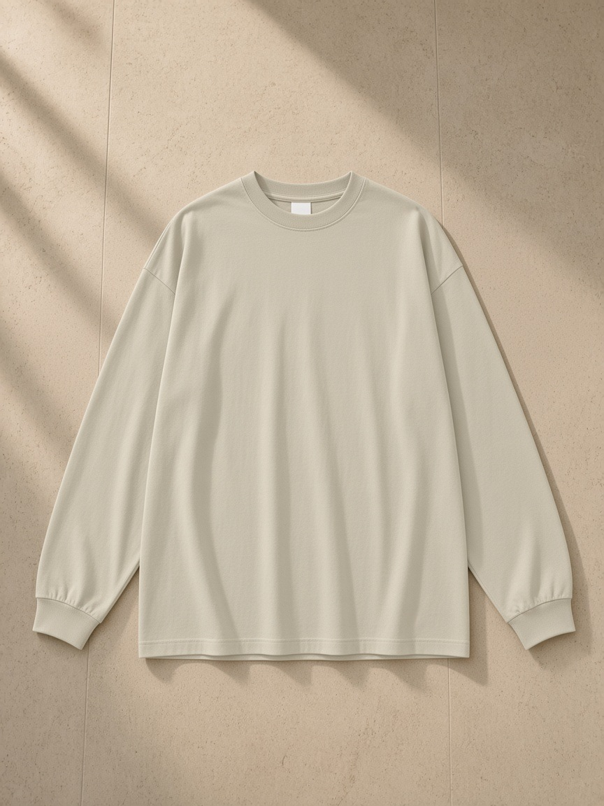 Oversized Long Sleeve T-Shirt in Sand Color, laid flat on pale limestone