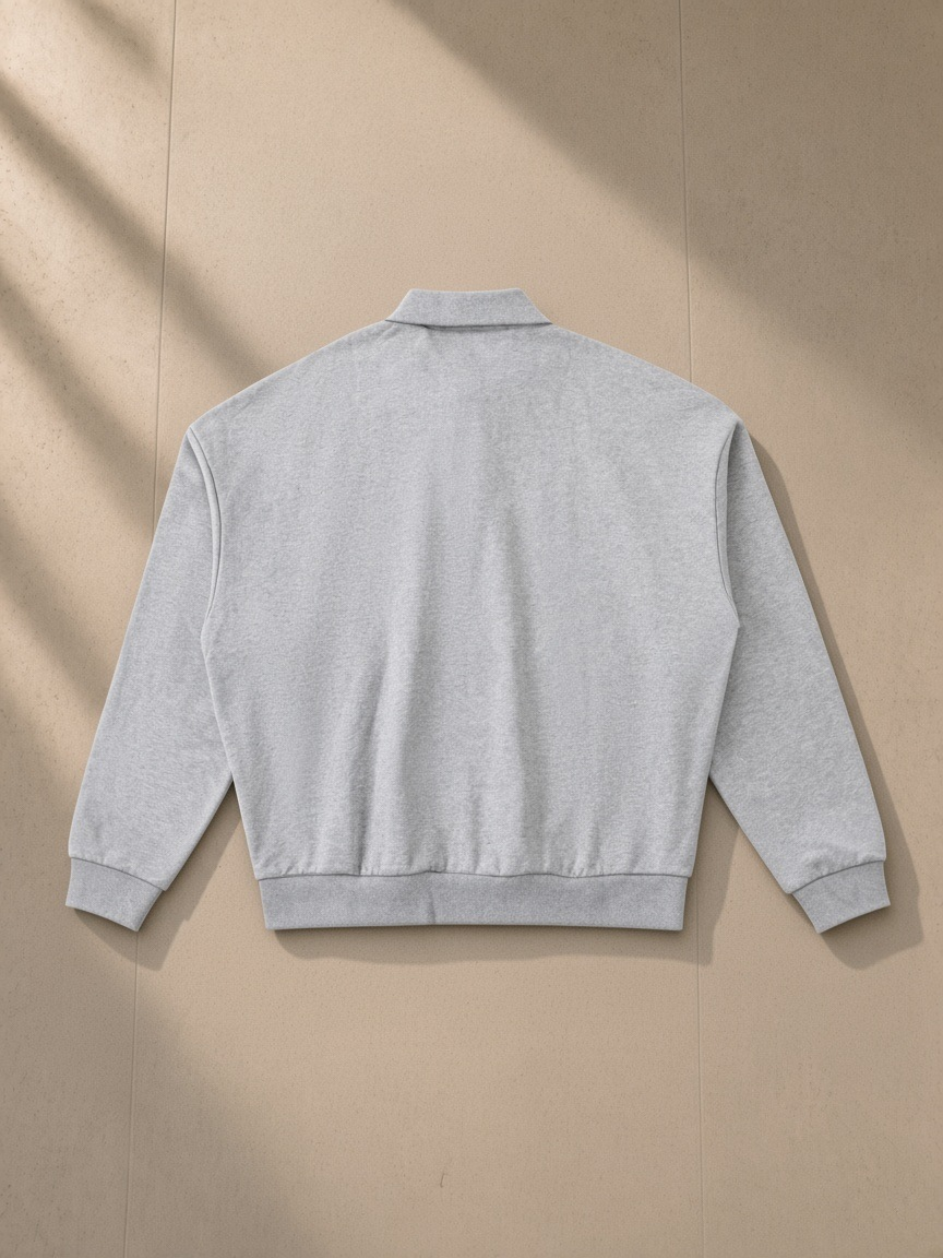 Heavyweight fleece polo sweatshirt in Flower Gray, laid flat on pale limestone, back view