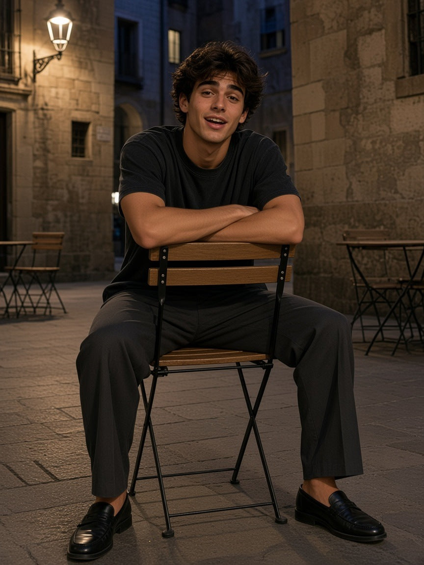 Man in the Marcel Afters Bamboo Slub Snow Washed T-Shirt in Black in a Gothic Quarter plaza in Barcelona at night