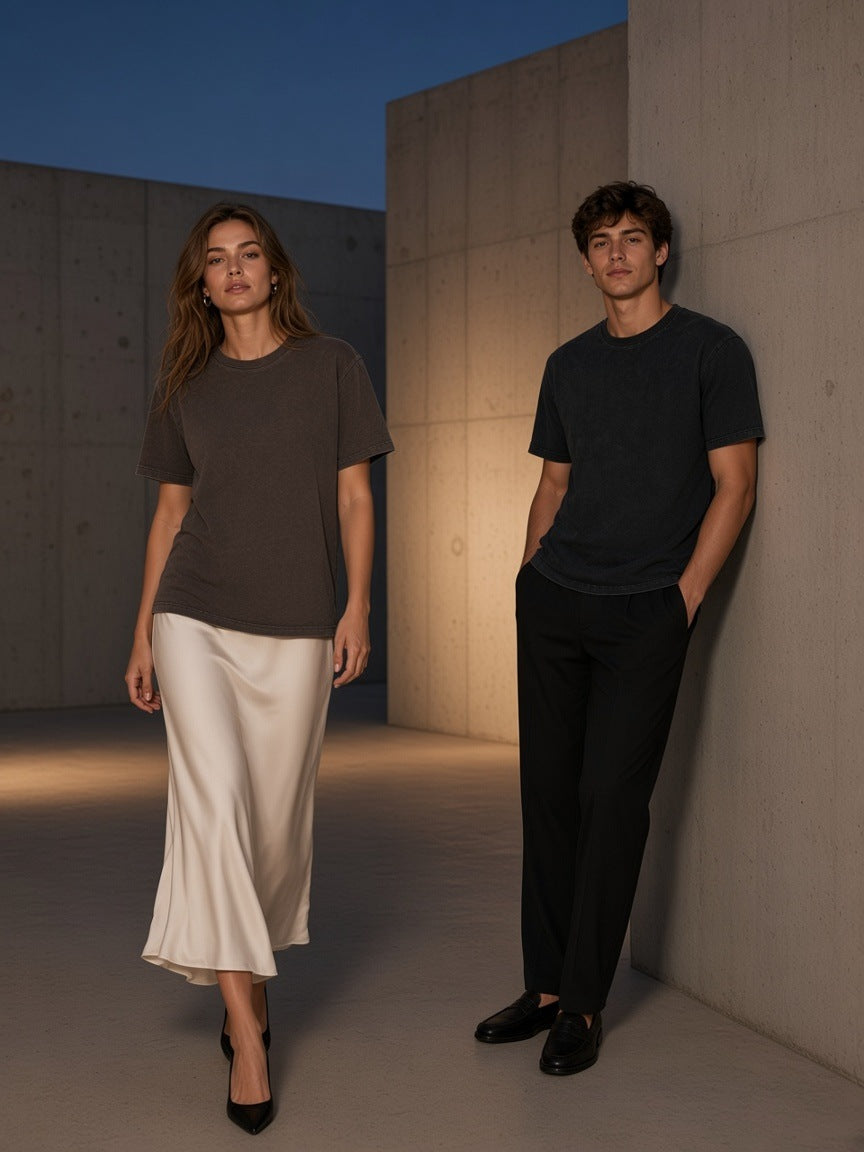 Two people in the Marcel Afters Bamboo Slub Snow Washed T-Shirt in Coffee and Black in a concrete courtyard in Tokyo at blue hour