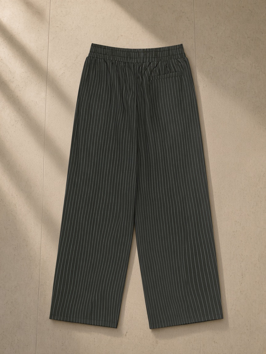 Striped Pleated Pants in Black, laid flat on pale limestone, back view