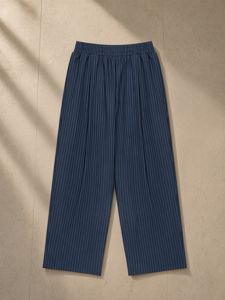 Striped Pleated Pants in Navy Blue, laid flat on pale limestone