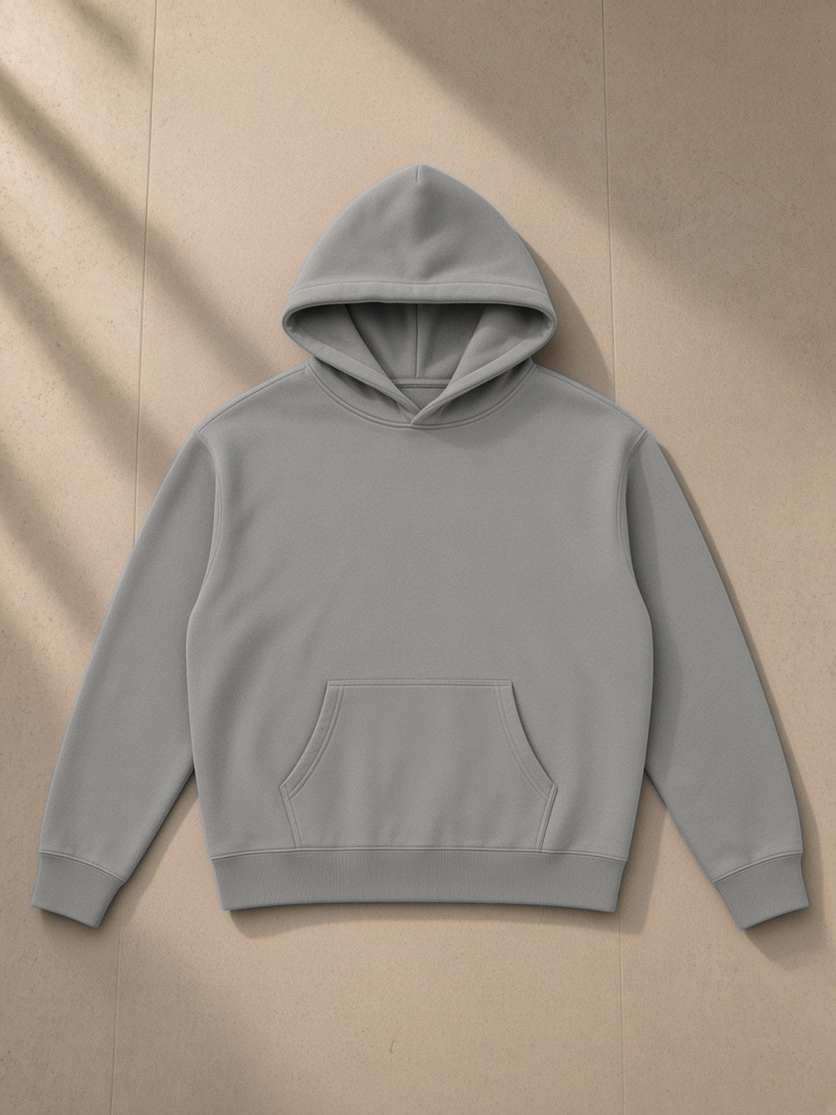 Oversize fleeced hoodie in Light Gray, laid flat on pale limestone