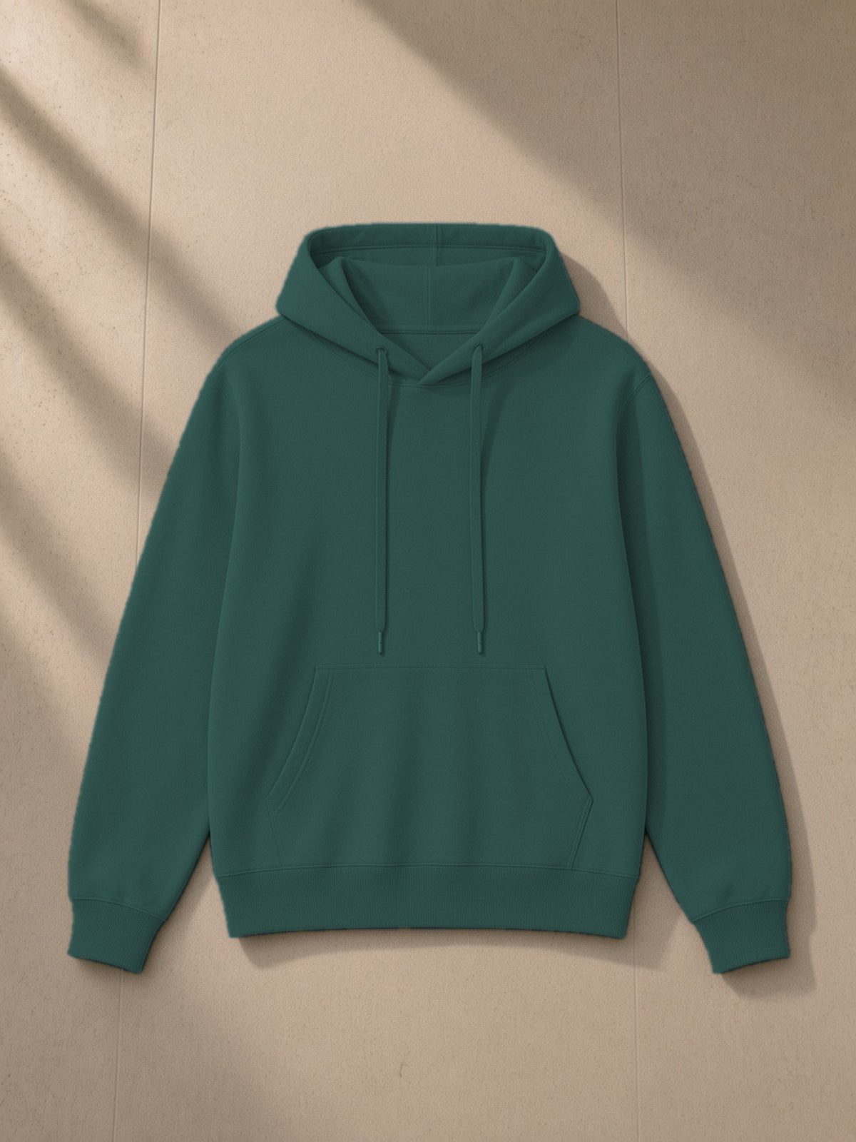 Unisex classic cotton hoodie in Olive Green, laid flat on pale limestone