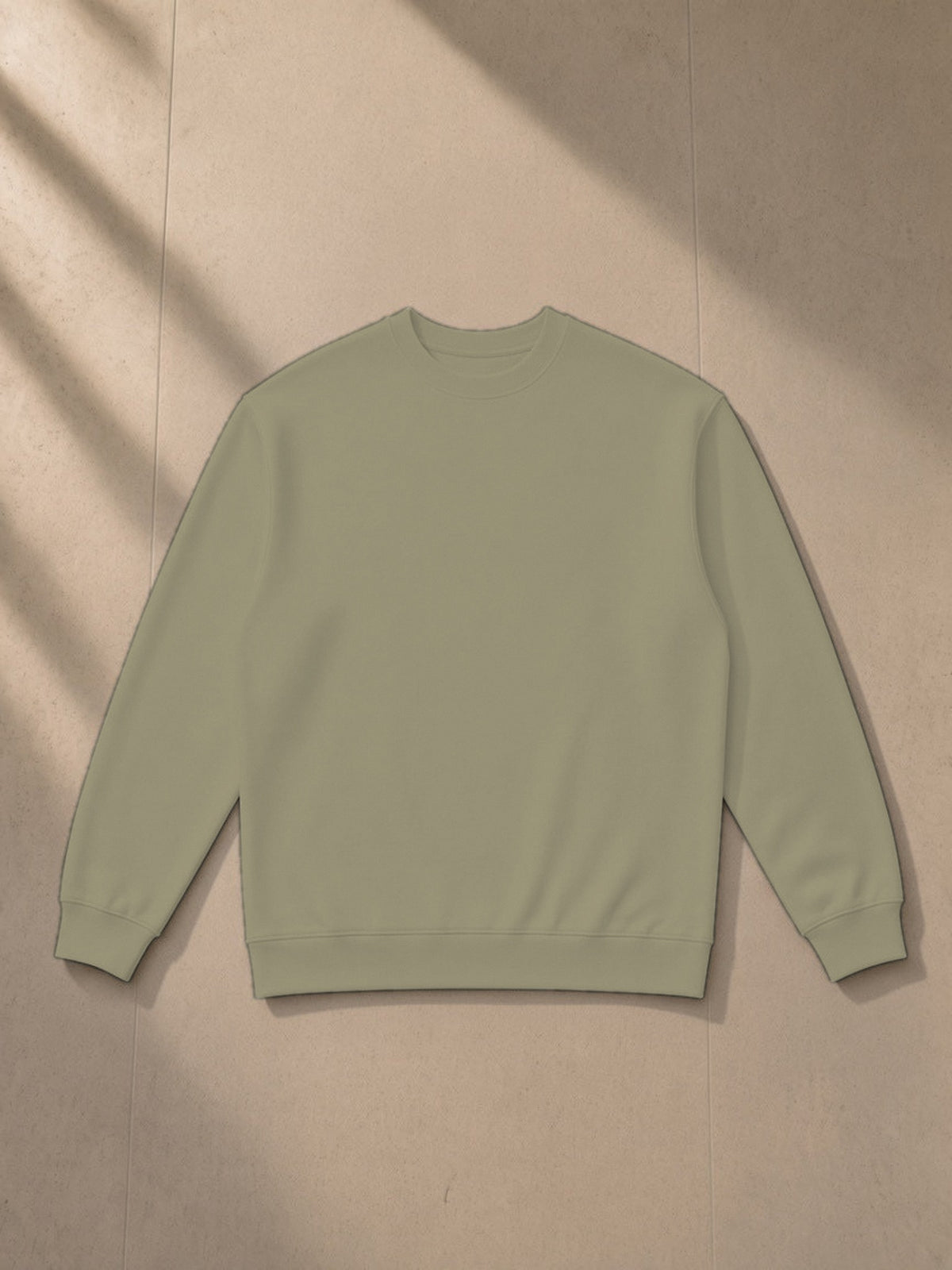 Oversized Crewneck Sweatshirt in Gray Green, laid flat on pale limestone, front view