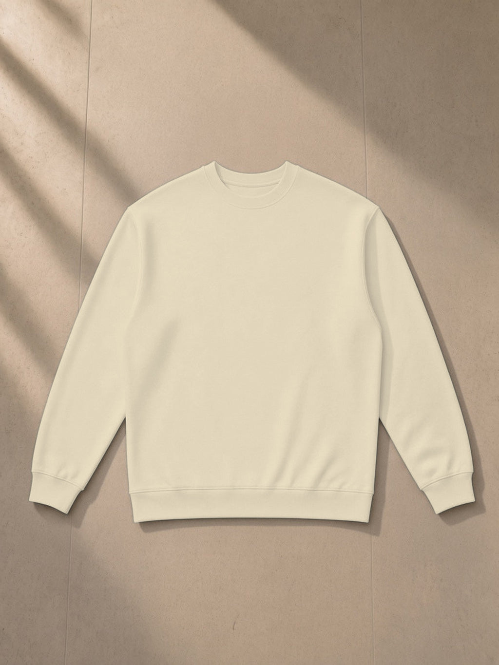 Oversized Crewneck Sweatshirt in Light Camel, laid flat on pale limestone, front view