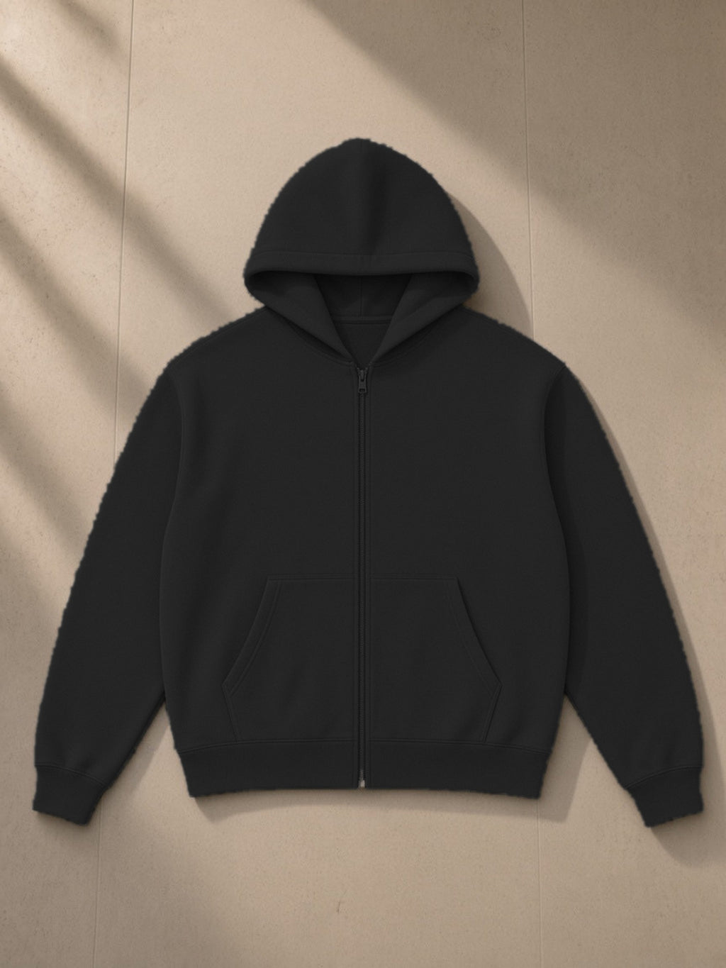 Essential fleece zip-through hoodie in Black, laid flat on pale limestone, front view