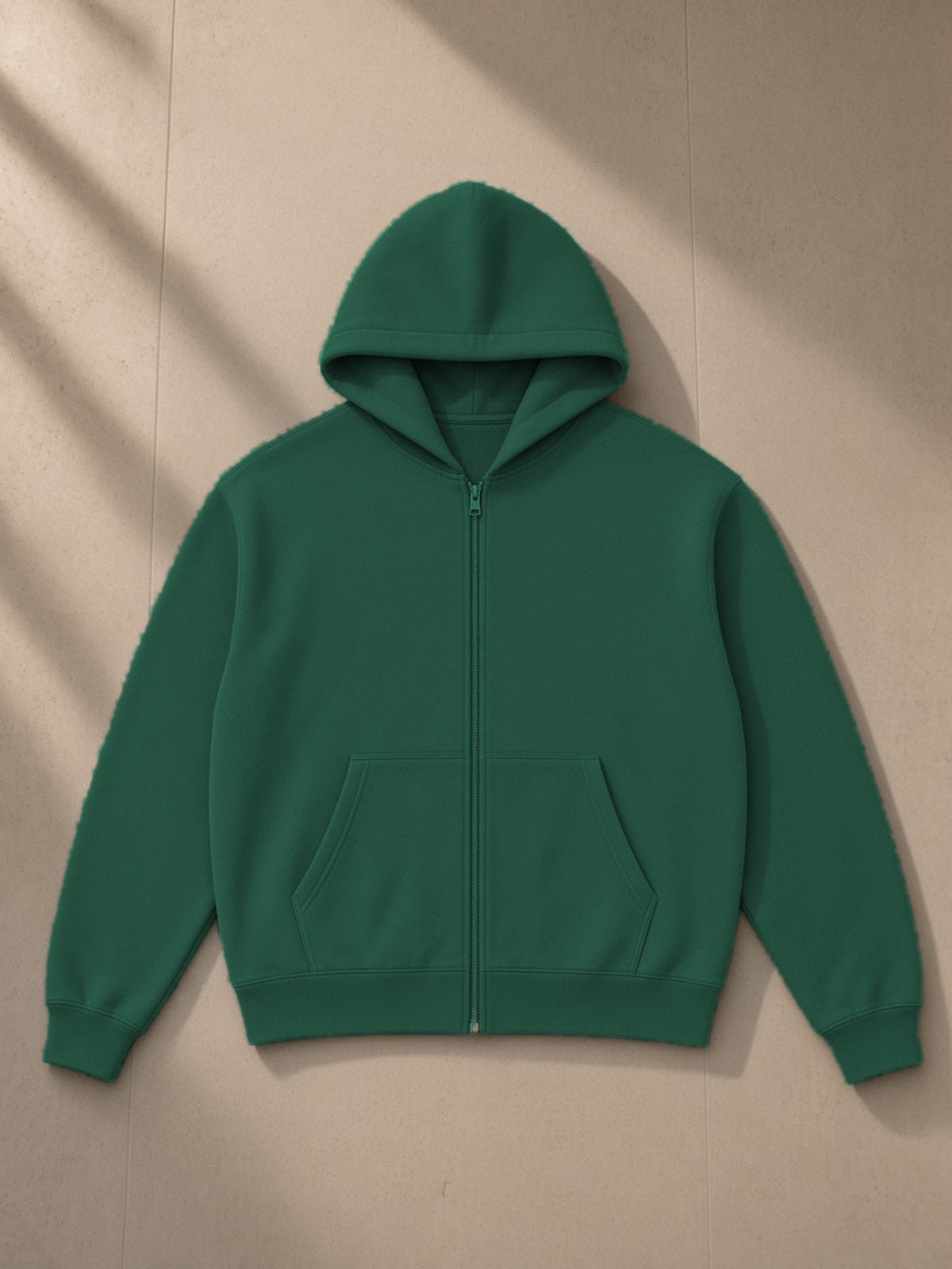 Essential fleece zip-through hoodie in Eden Green, laid flat on pale limestone, front view