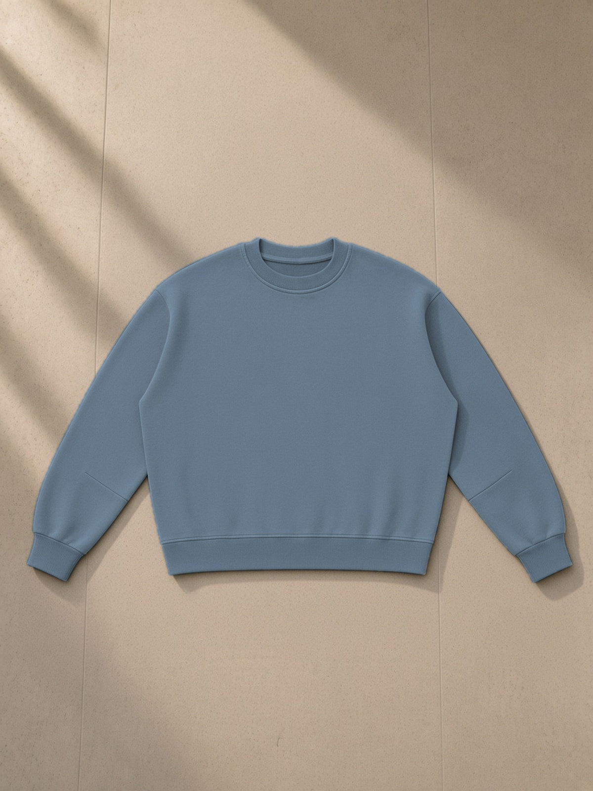 Boxy Vintage Washed Sweatshirt in Gray Blue, laid flat on pale limestone, front view