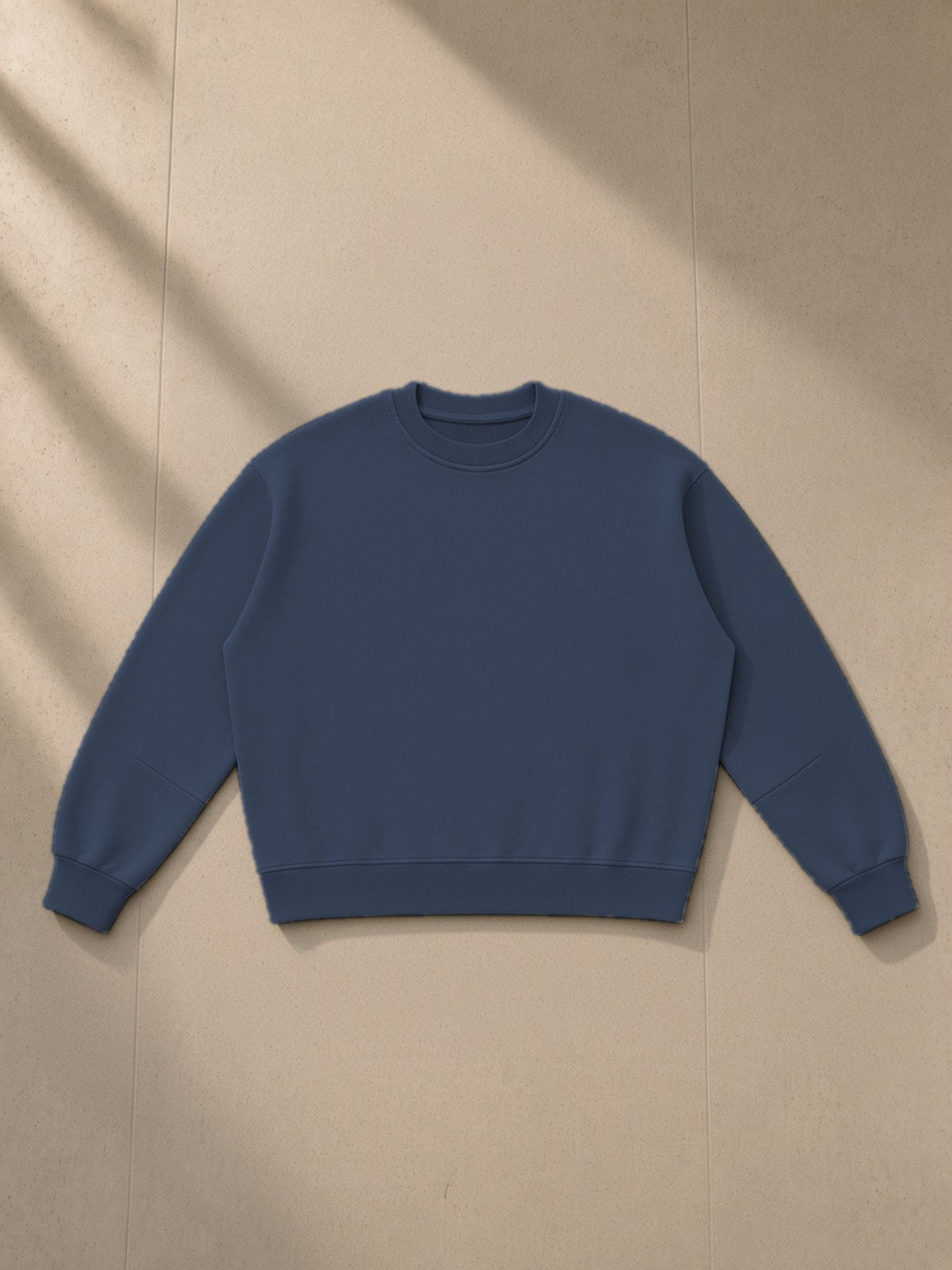 Boxy Vintage Washed Sweatshirt in Navy Blue, laid flat on pale limestone, front view