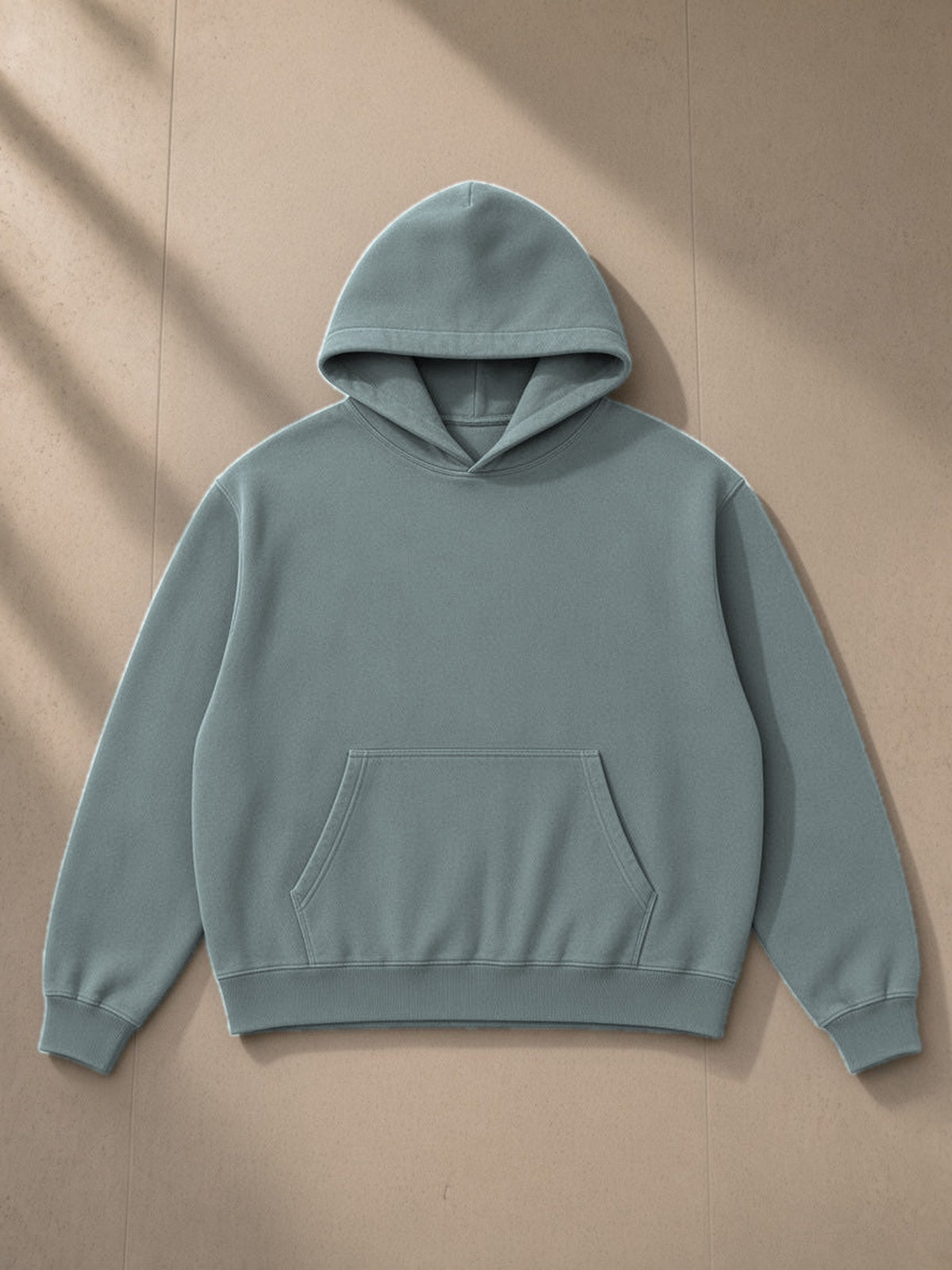 Heavyweight Vintage Wash Boxy Hoodie in Gray Blue, laid flat on pale limestone, front view