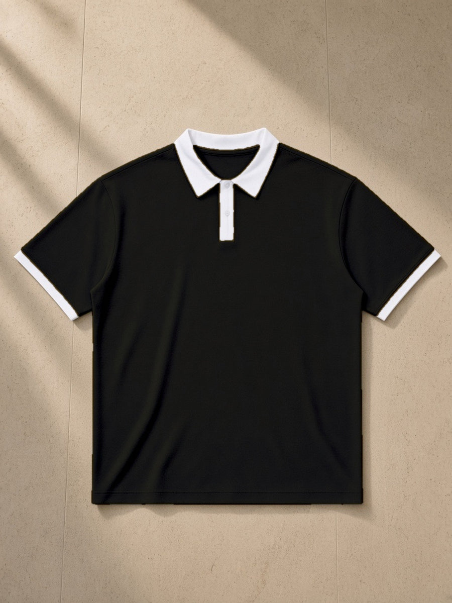 Color Block Polo Shirt in Black with White, laid flat on pale limestone, front view