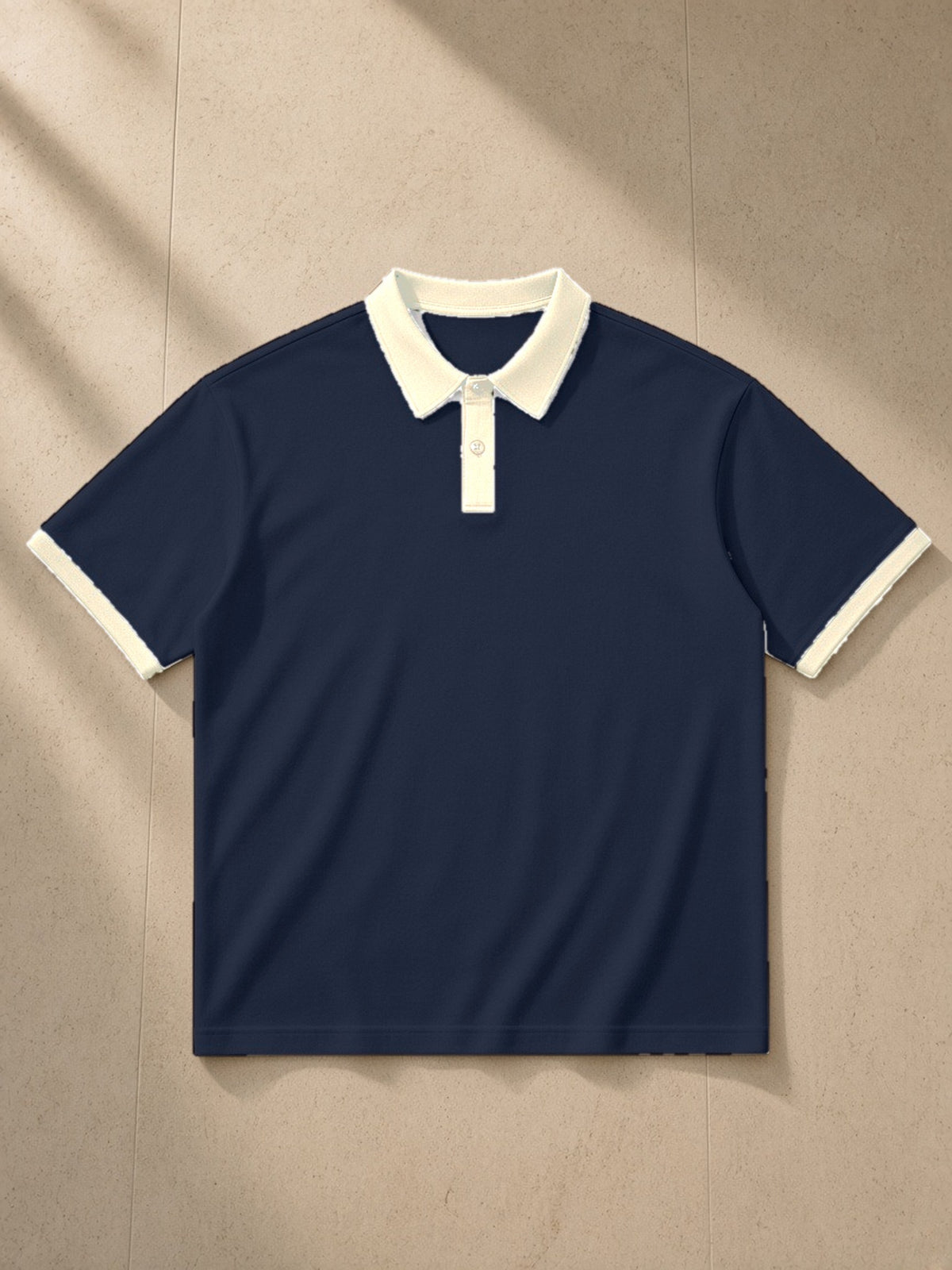 Color Block Polo Shirt in Navy Blue with Apricot, laid flat on pale limestone, front view